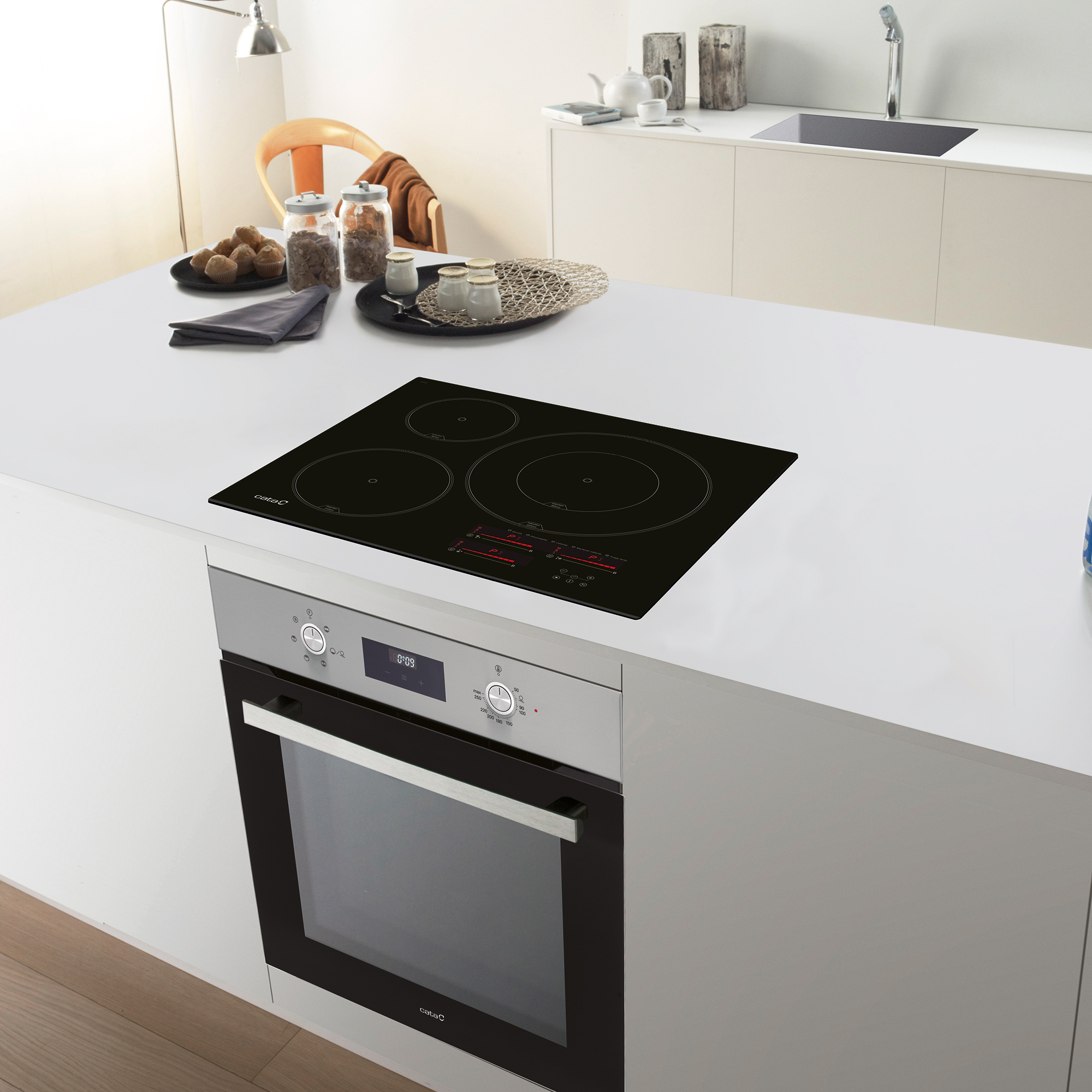 Isla de cocina con encimera negra y horno. Fondo con gabinetes blancos y silla de madera.