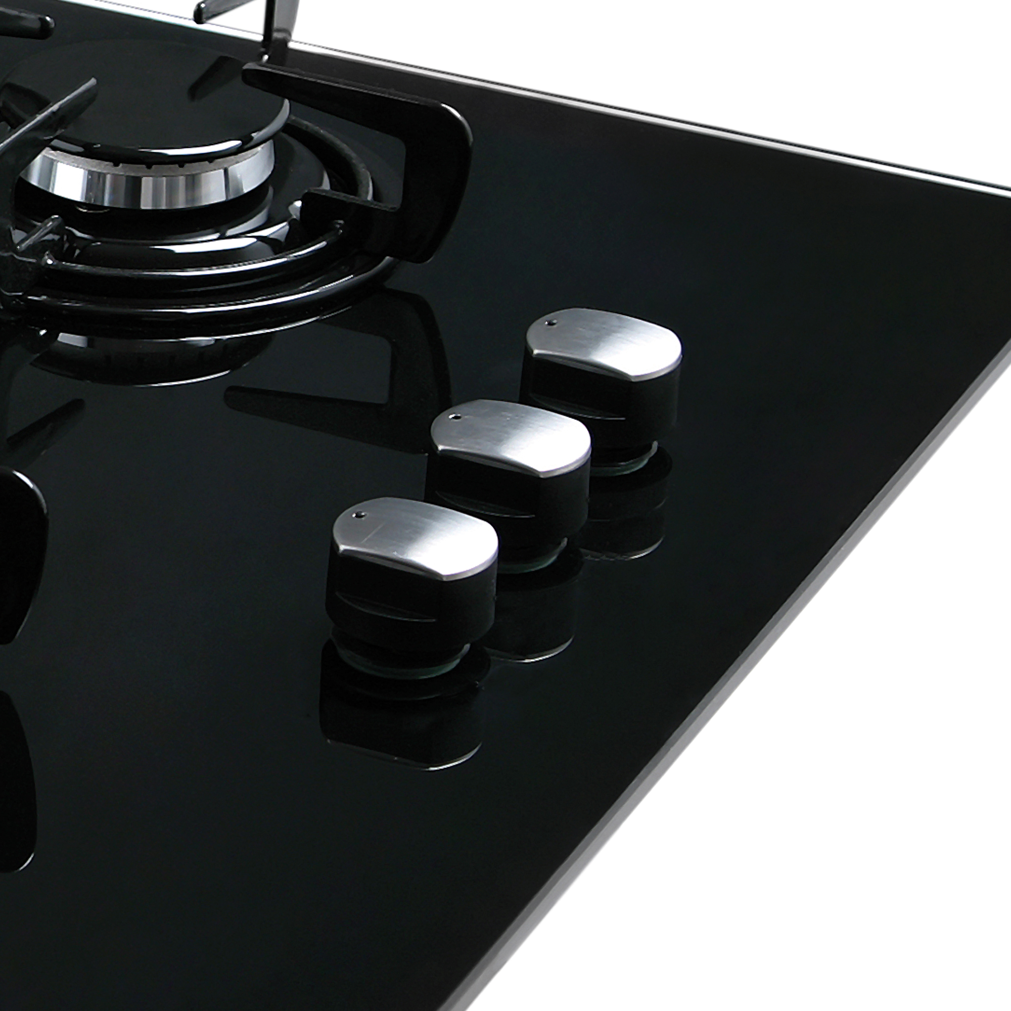 Piano cottura in vetro nero con tre manopole argentate. Un bruciatore è visibile. Sfondo bianco.