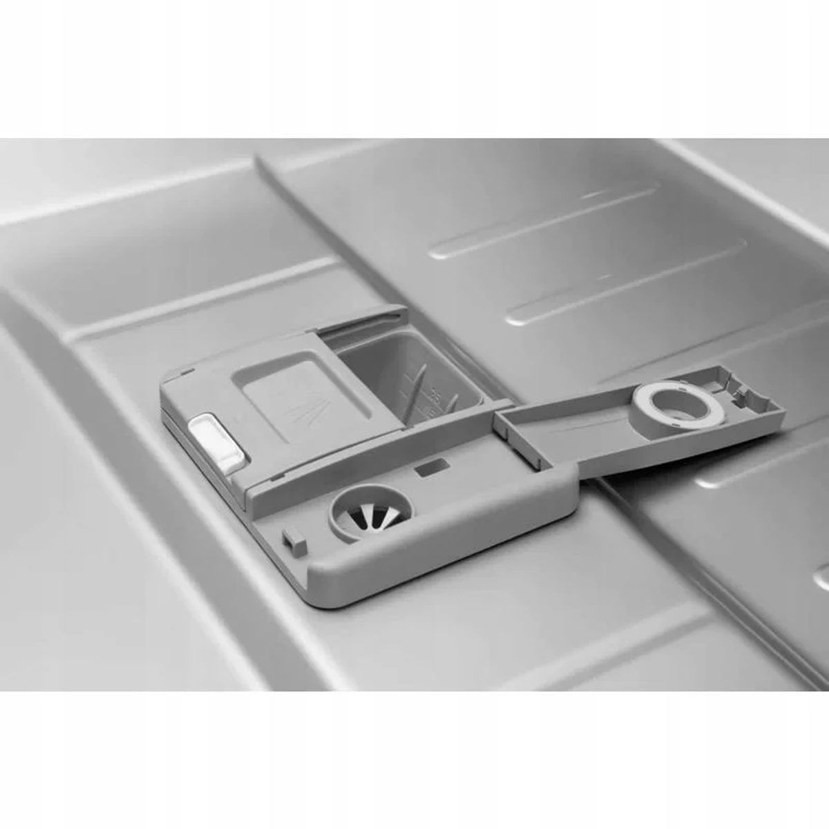 Dozownik detergentu do zmywarki, otwarty, w komorze zmywarki, skala szarości.