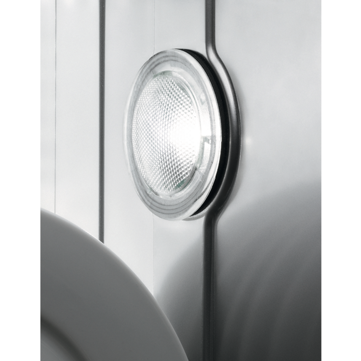 Un apparecchio di illuminazione circolare brillante montato su una parete bianca.