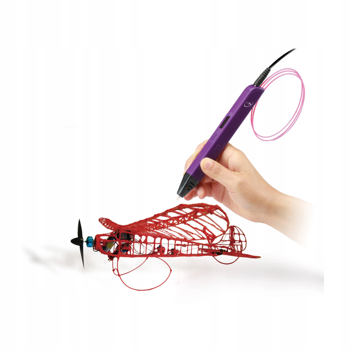 Una mano usa una penna 3D viola per creare un modello di aeroplano rosso con filamento rosa.