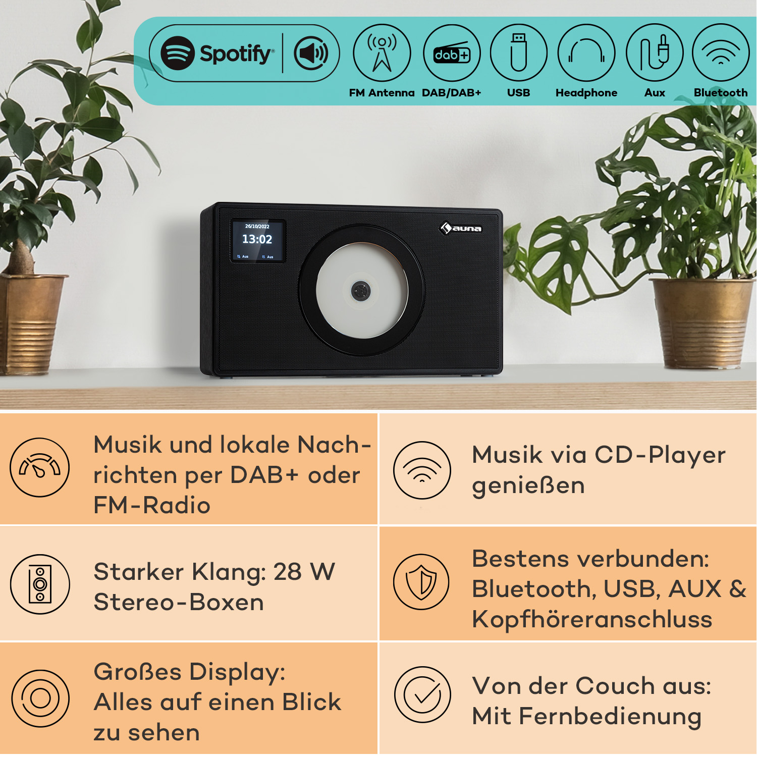 Schwarzes Radio mit Display und Knöpfen, Pflanzen und Symbolen, weißer Tisch.