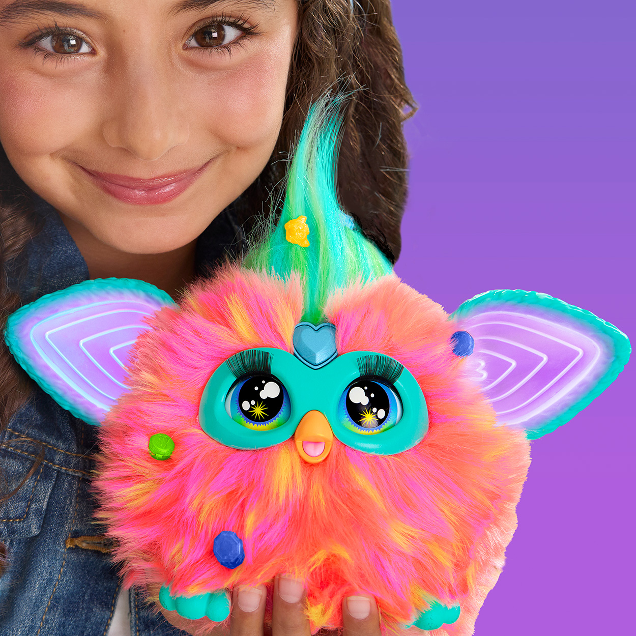 Ein Mädchen hält ein farbenfrohes Furby-Spielzeug.