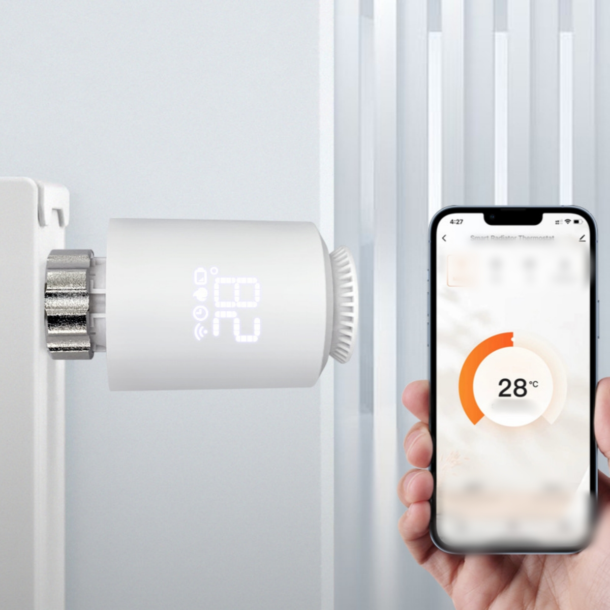 Ein intelligenter Heizkörperthermostat zeigt 28 Grad auf dem Gerät und Telefon.