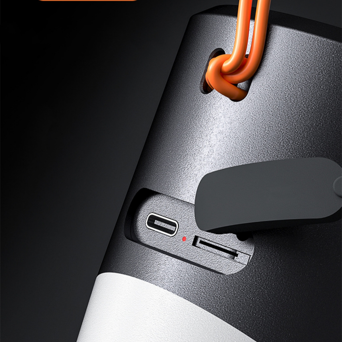 Schwarz-weißer Lautsprecher mit orangefarbenem Riemen, USB- und SD-Kartenanschlüssen.