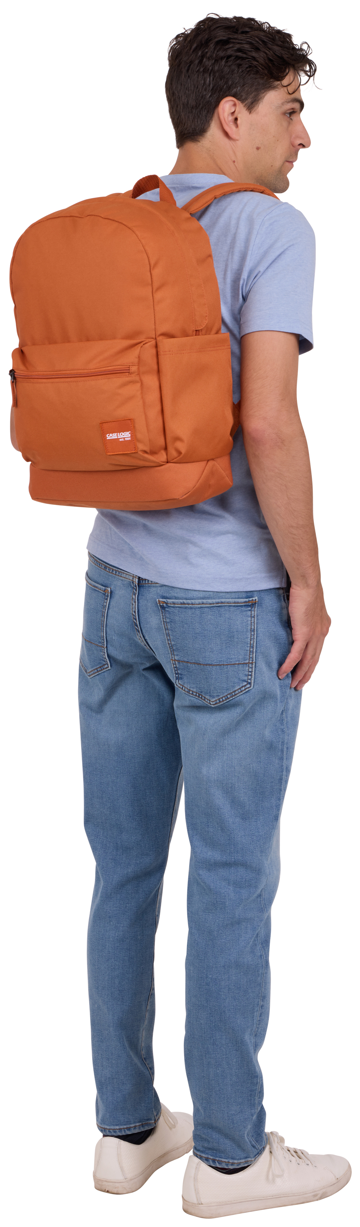 Un homme avec un sac à dos. Le sac à dos est orange et il porte un jean et une chemise bleue.