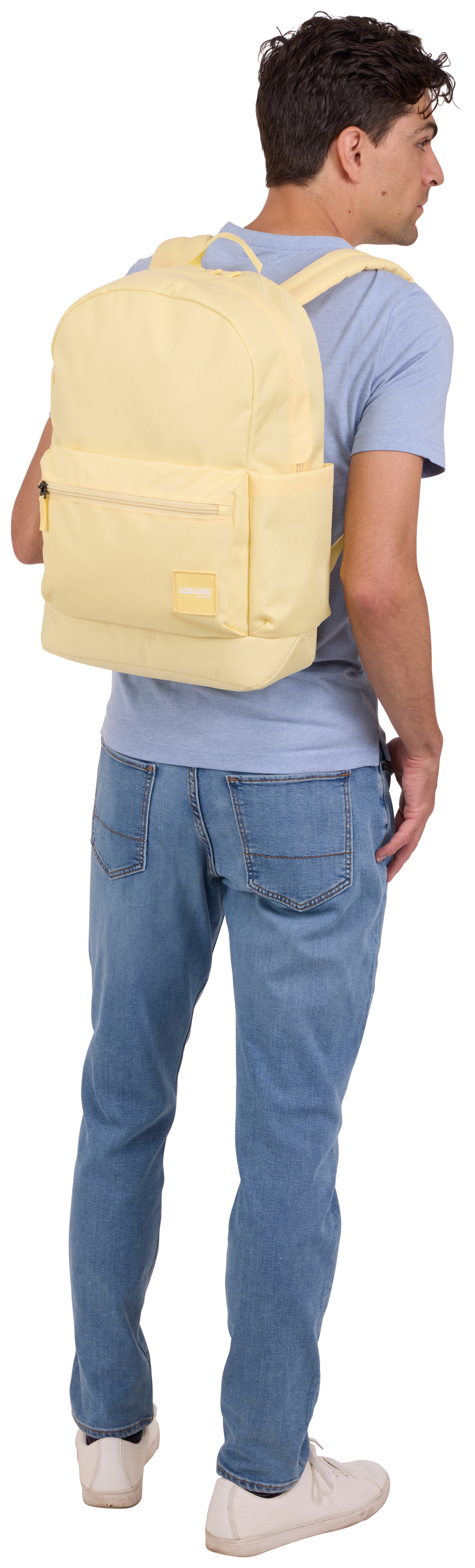 Une personne portant un sac à dos jaune, de dos à la caméra.
