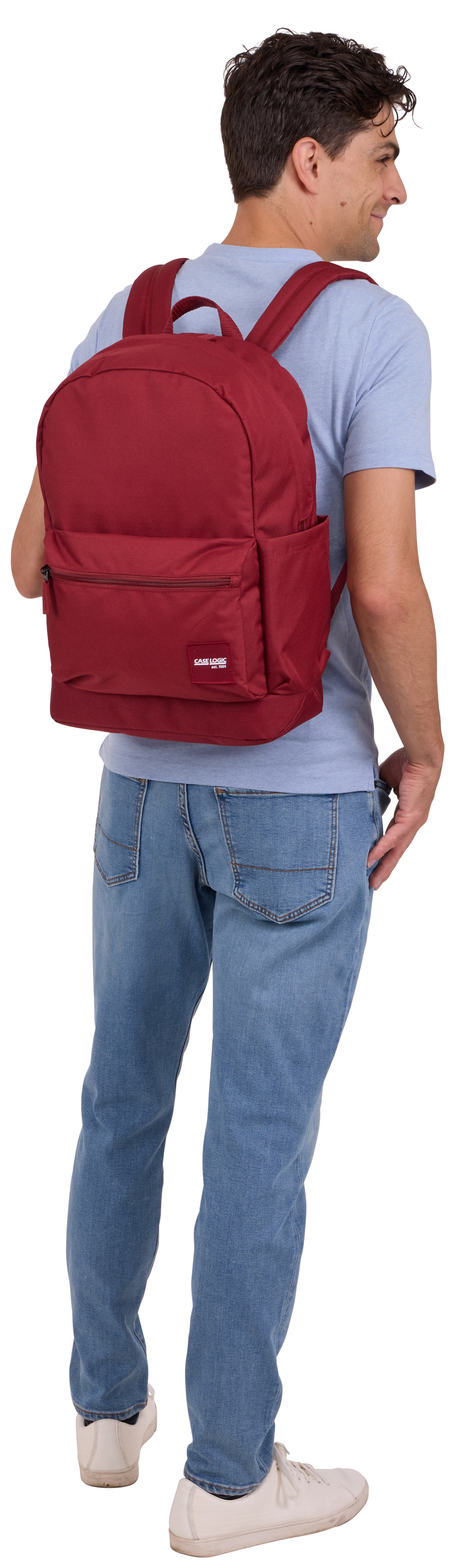 Un uomo con zaino rosso, jeans blu e camicia azzurra, visto da dietro.