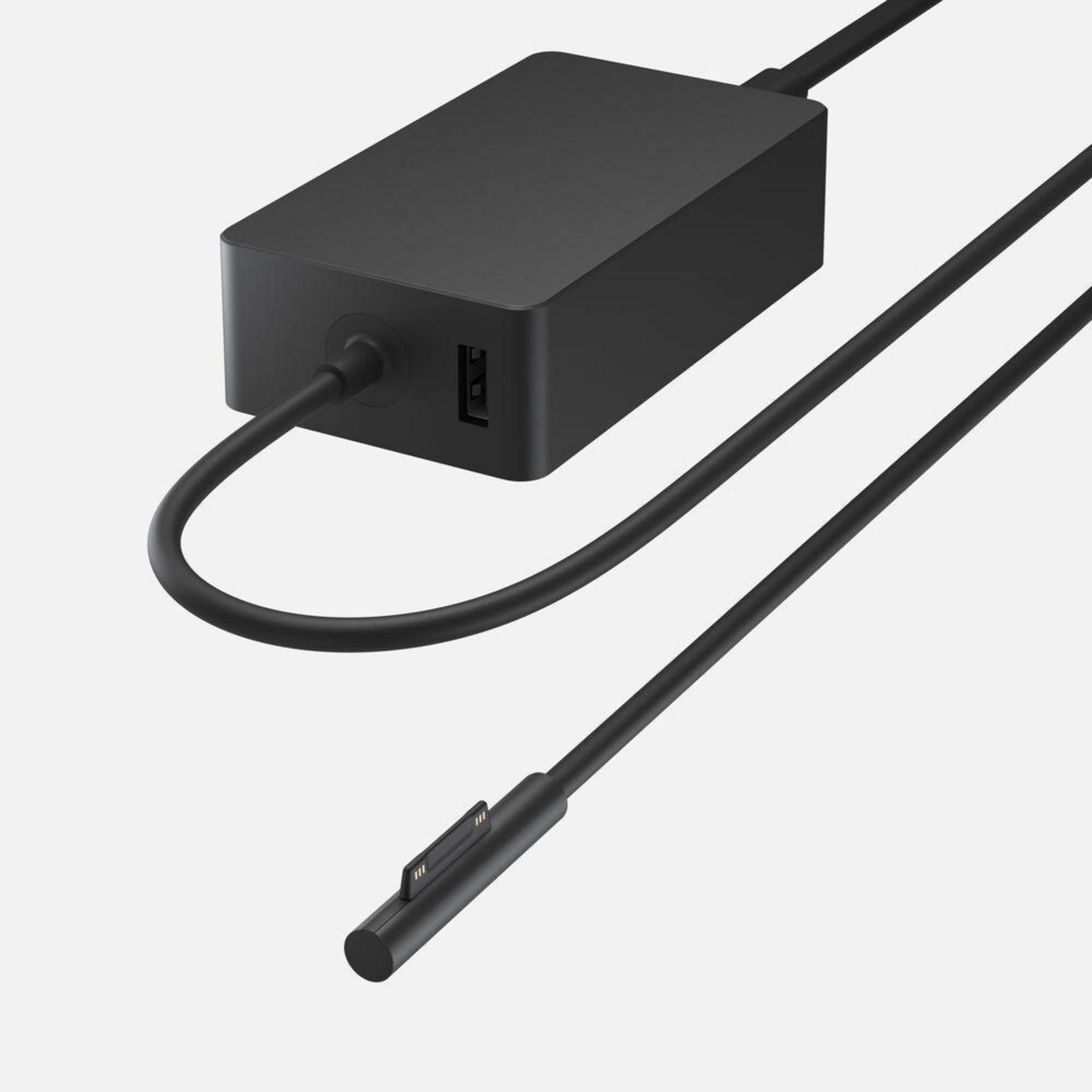 Schwarzes Netzteil mit USB-Anschluss und Ladekabel, auf weißem Untergrund.
