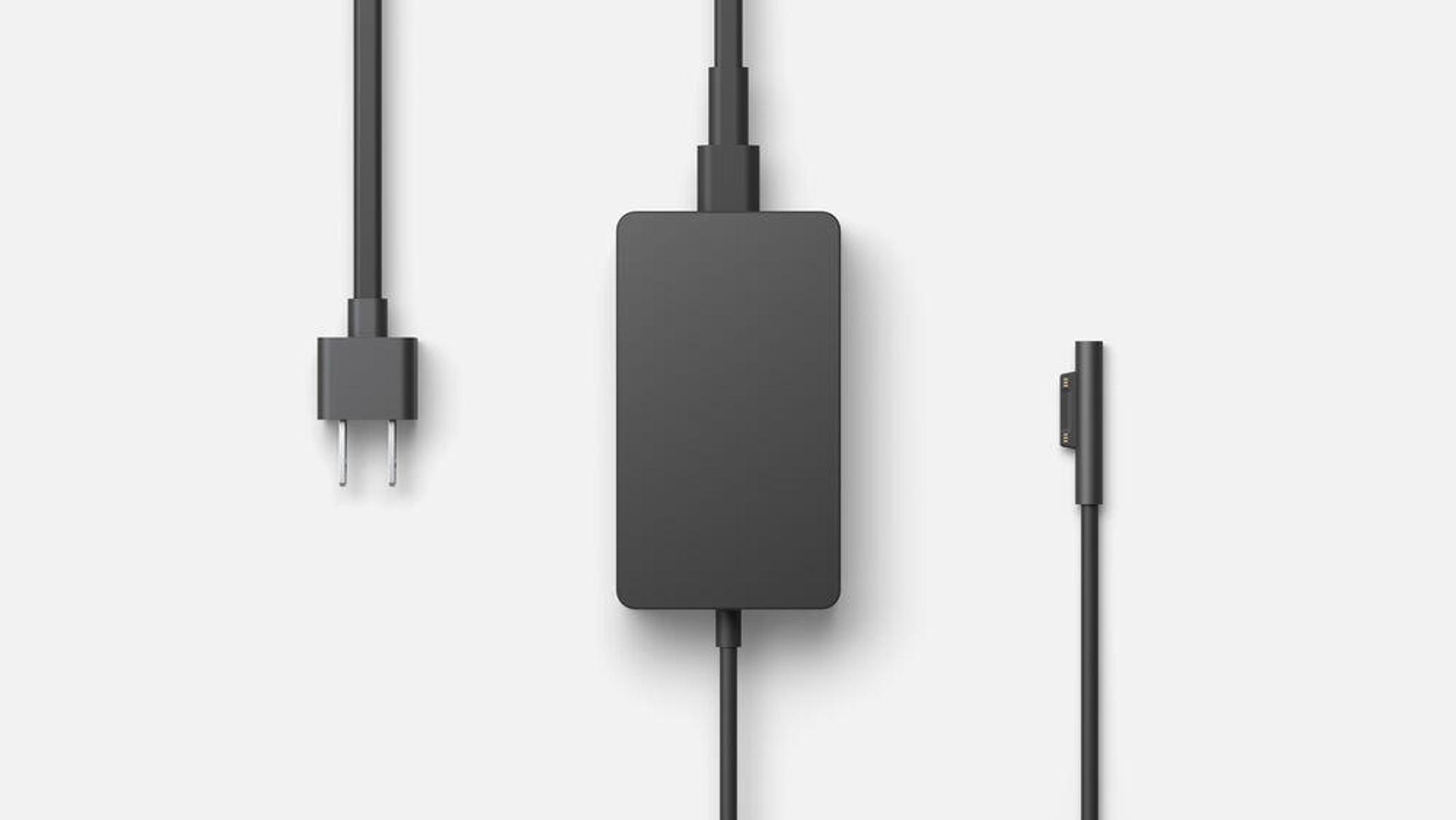 Ein schwarzer Netzadapter mit drei Teilen: Stecker, Adapter und Ladeende.