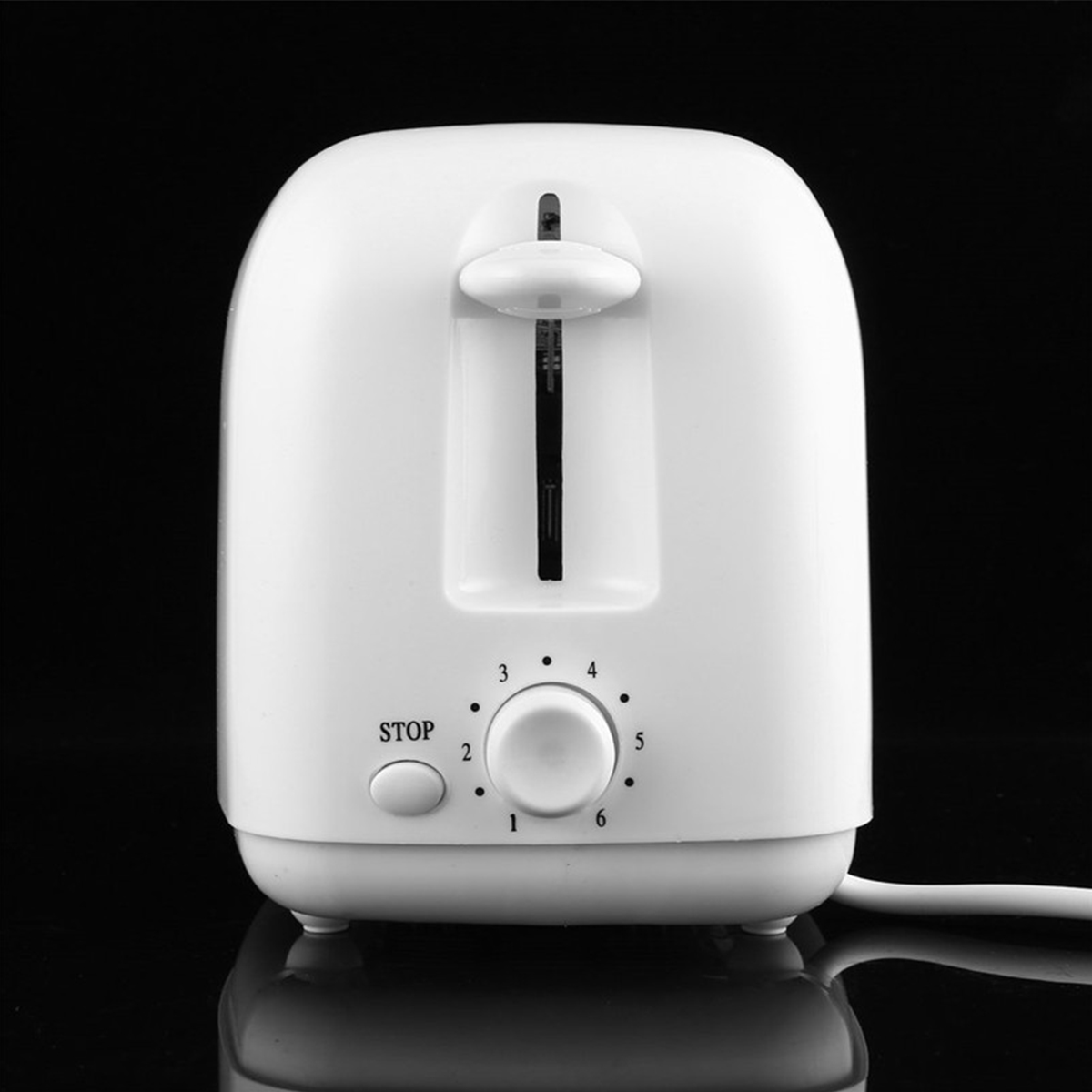Weißer Toaster auf schwarzer Oberfläche. Er hat ein Rad von 1-6 und eine Stopptaste.