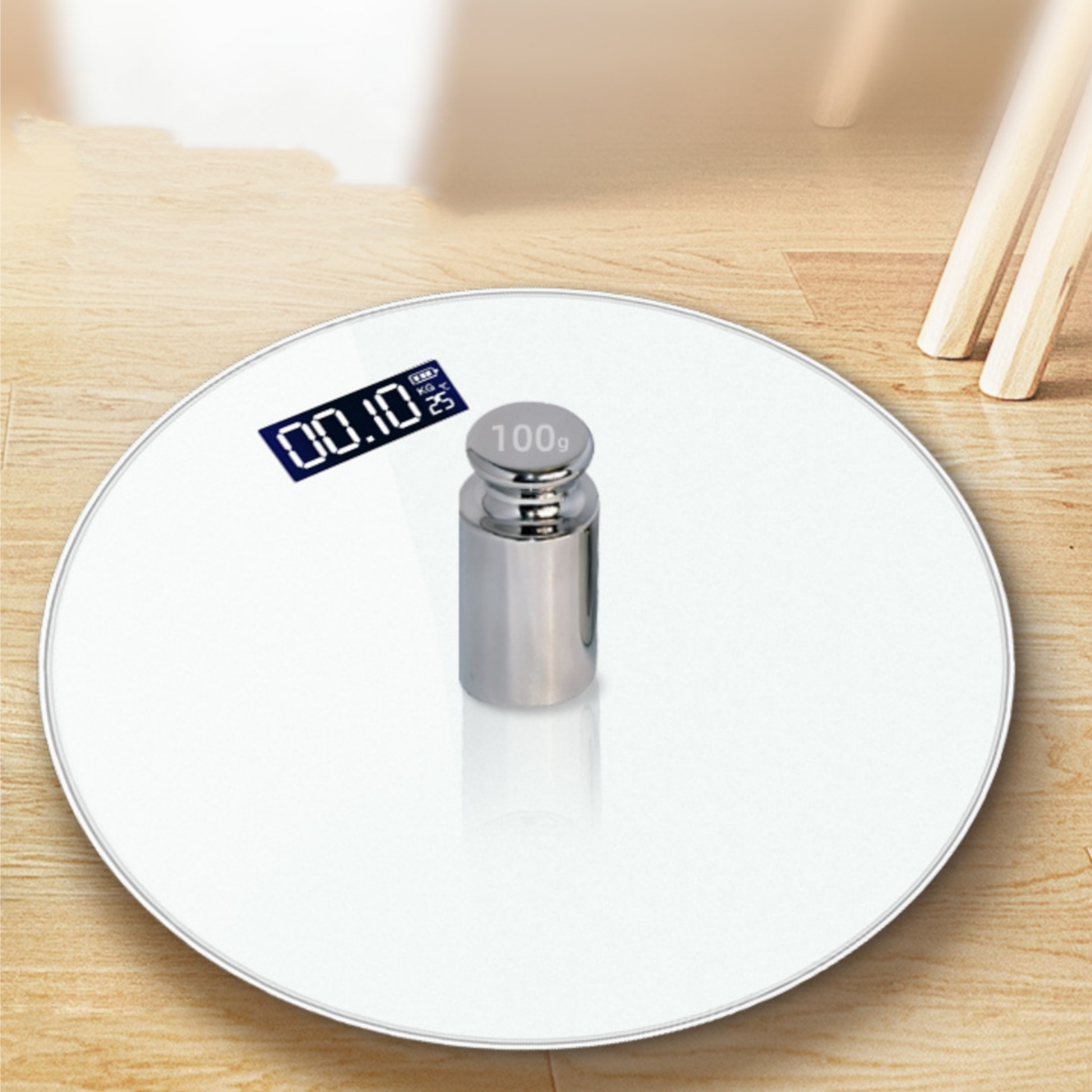 Eine weiße, runde Waage mit einem Gewicht und einer Digitalanzeige, die ein Gewicht von 00.10 kg zeigt.