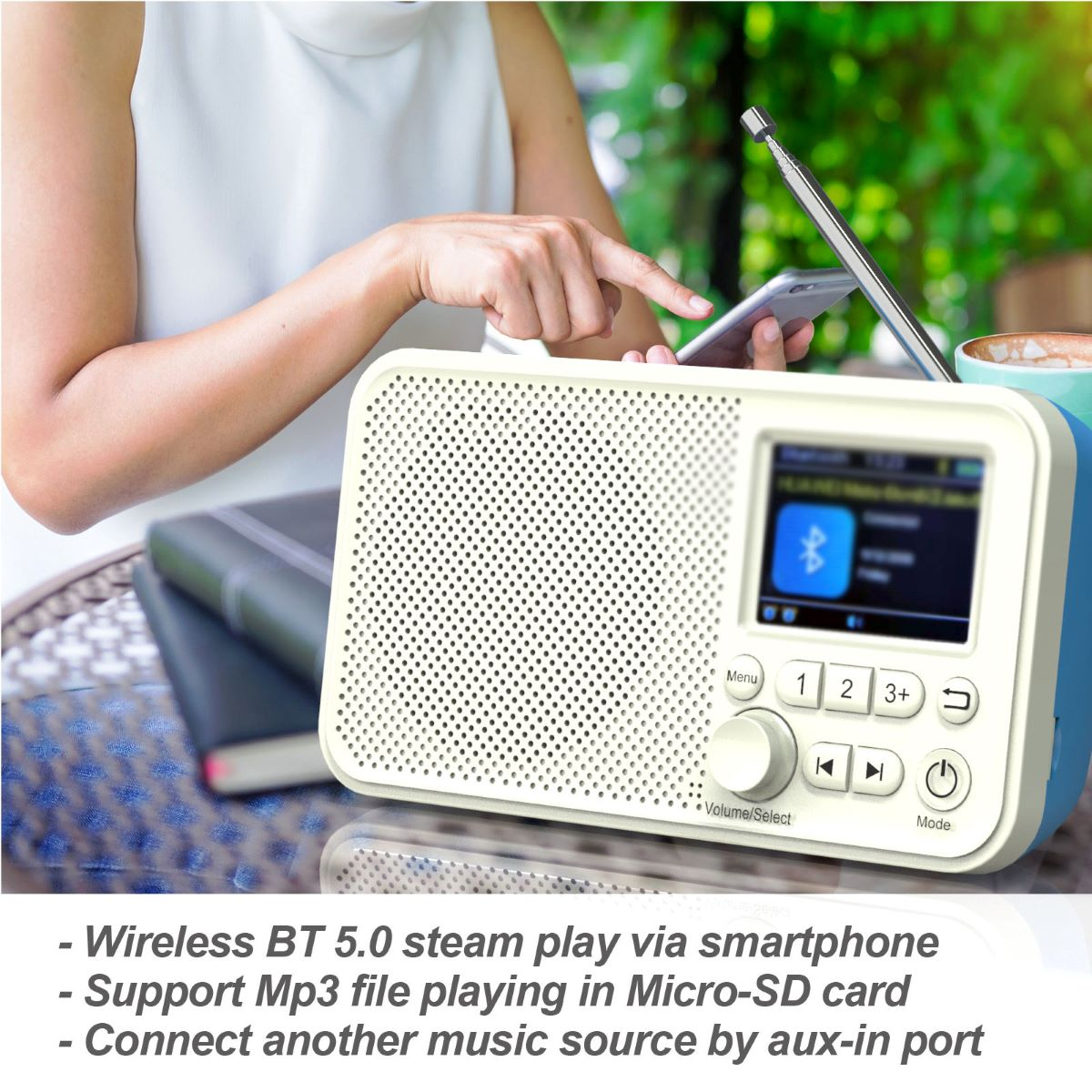 Ein cremefarbenes und blaues Radio mit Bildschirm und Knöpfen, eine Hand interagiert damit.