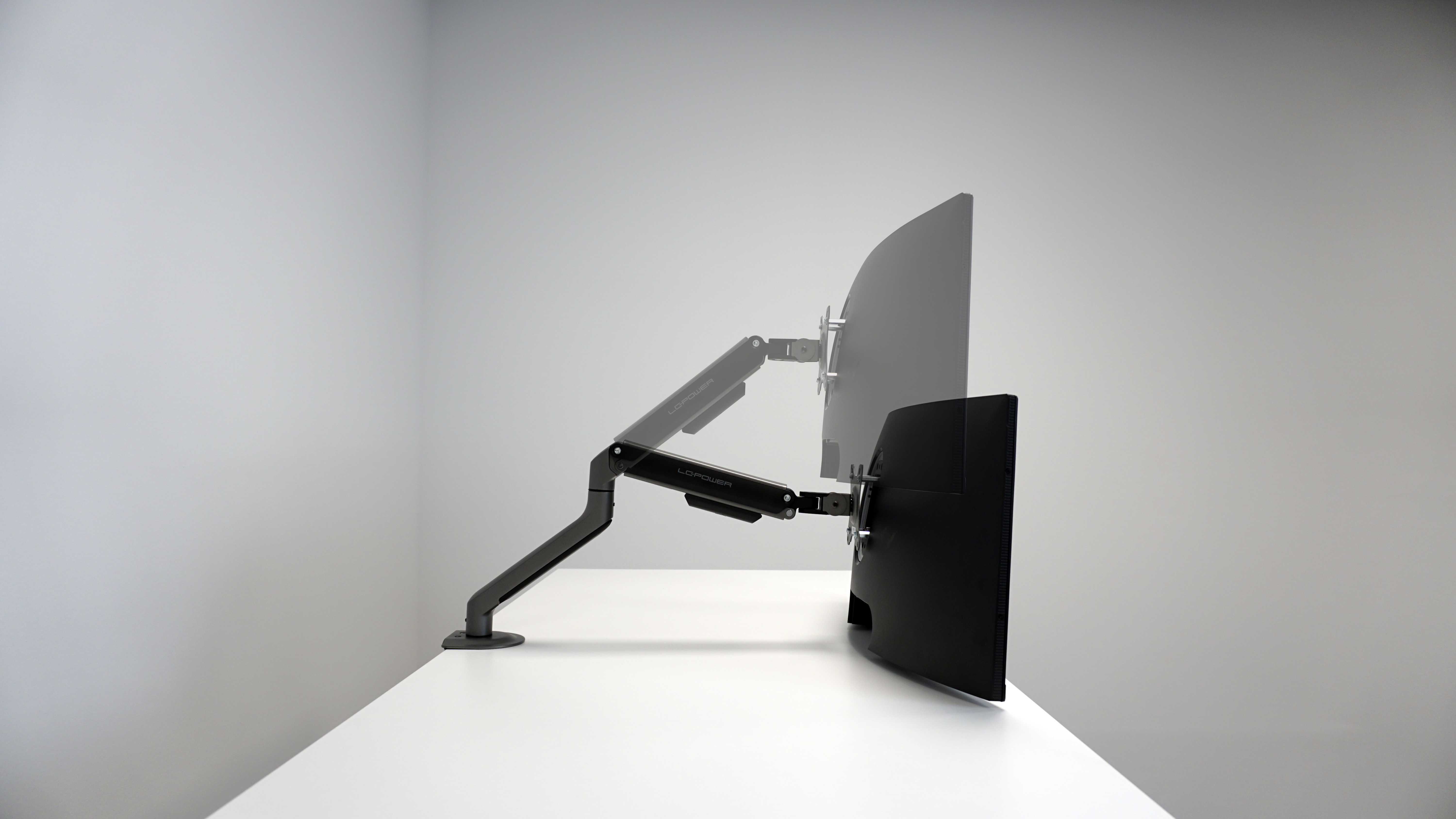 Un braccio per monitor con due schermi. Gli schermi sono in bianco e nero con sfondo bianco.
