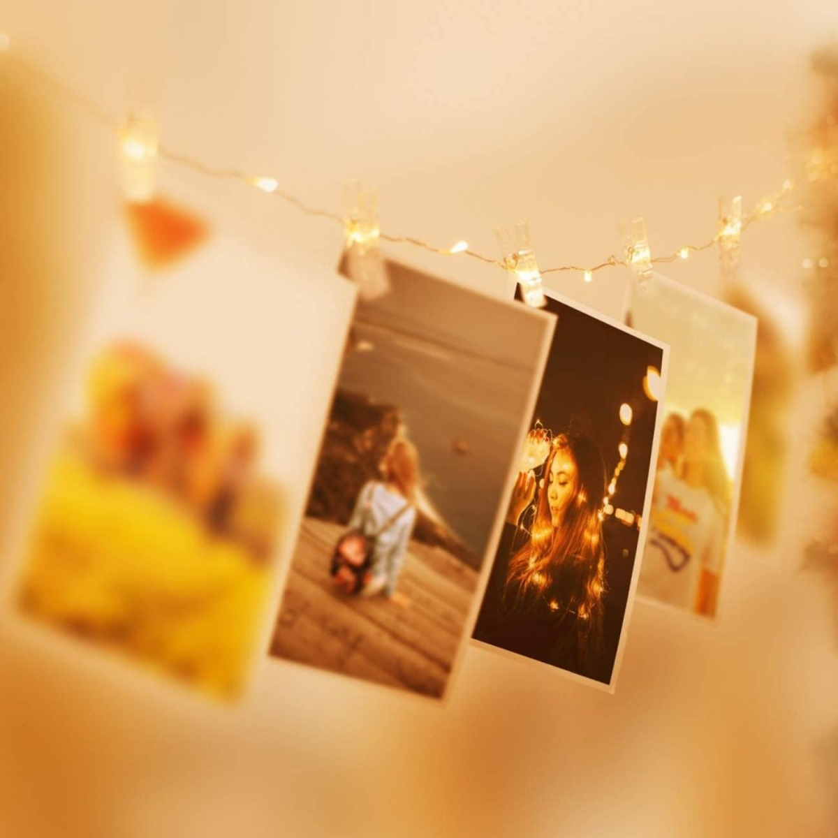 Fotos mit kleinen Lichtern an einer Schnur befestigt. Fotos mit verschwommenen Bildern, warmen Tönen.