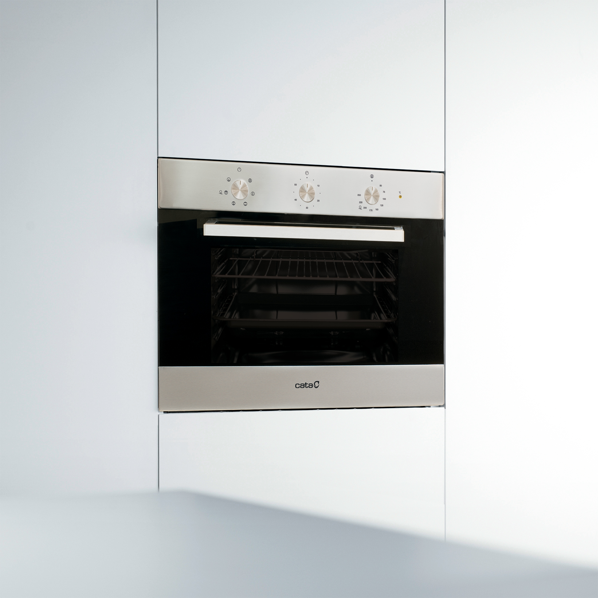 Horno empotrado, plateado y negro, con el logo de Cata. Gabinetes blancos a los lados.
