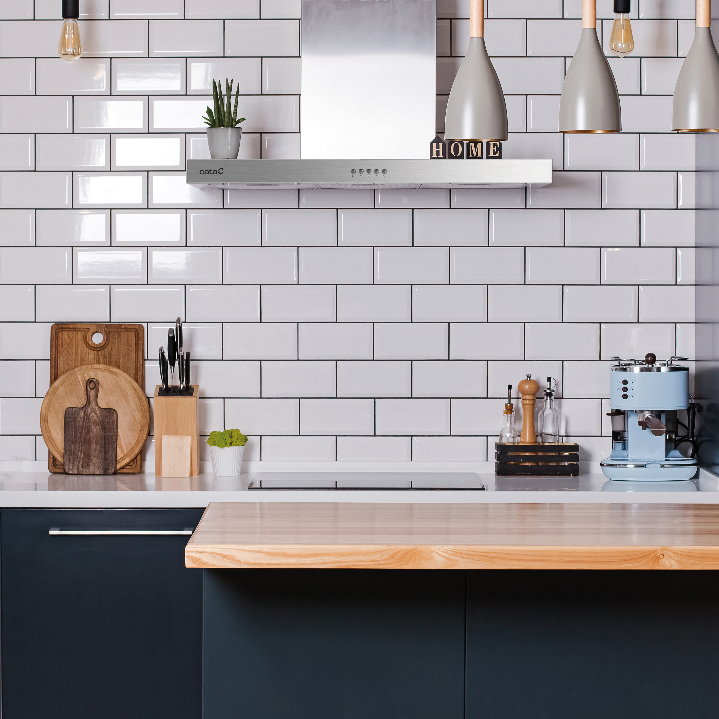 Cucina con piastrelle bianche della metropolitana, bancone in legno e macchina per caffè espresso blu. Cappa sopra.