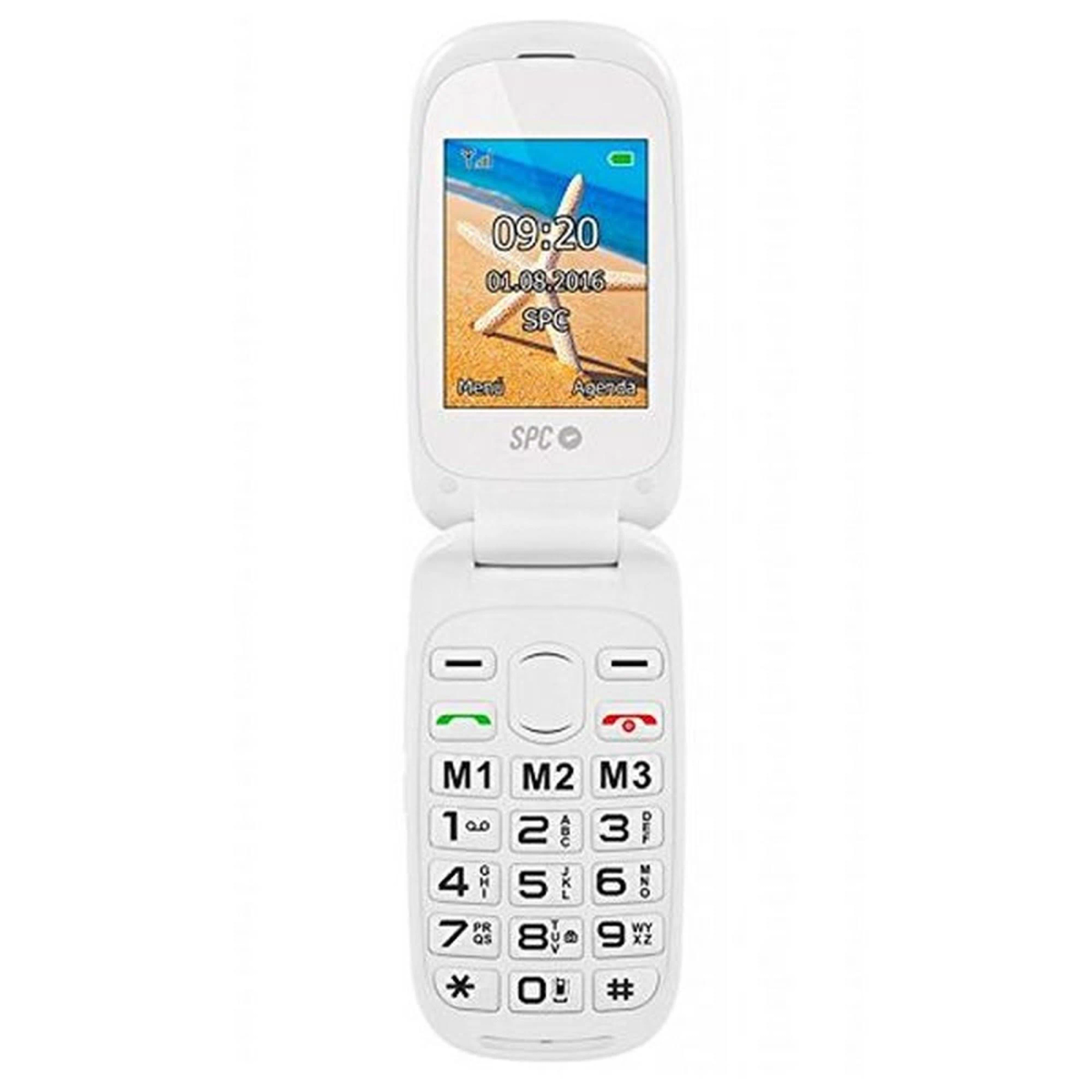 Un telefono a conchiglia bianco è aperto, mostrando una scena di spiaggia e l'ora, con tasti numerici sotto.