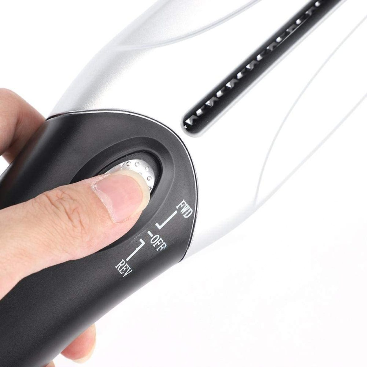 Nahaufnahme eines schwarzen und silbernen elektrischen Haarschneiders mit Finger auf dem Knopf.