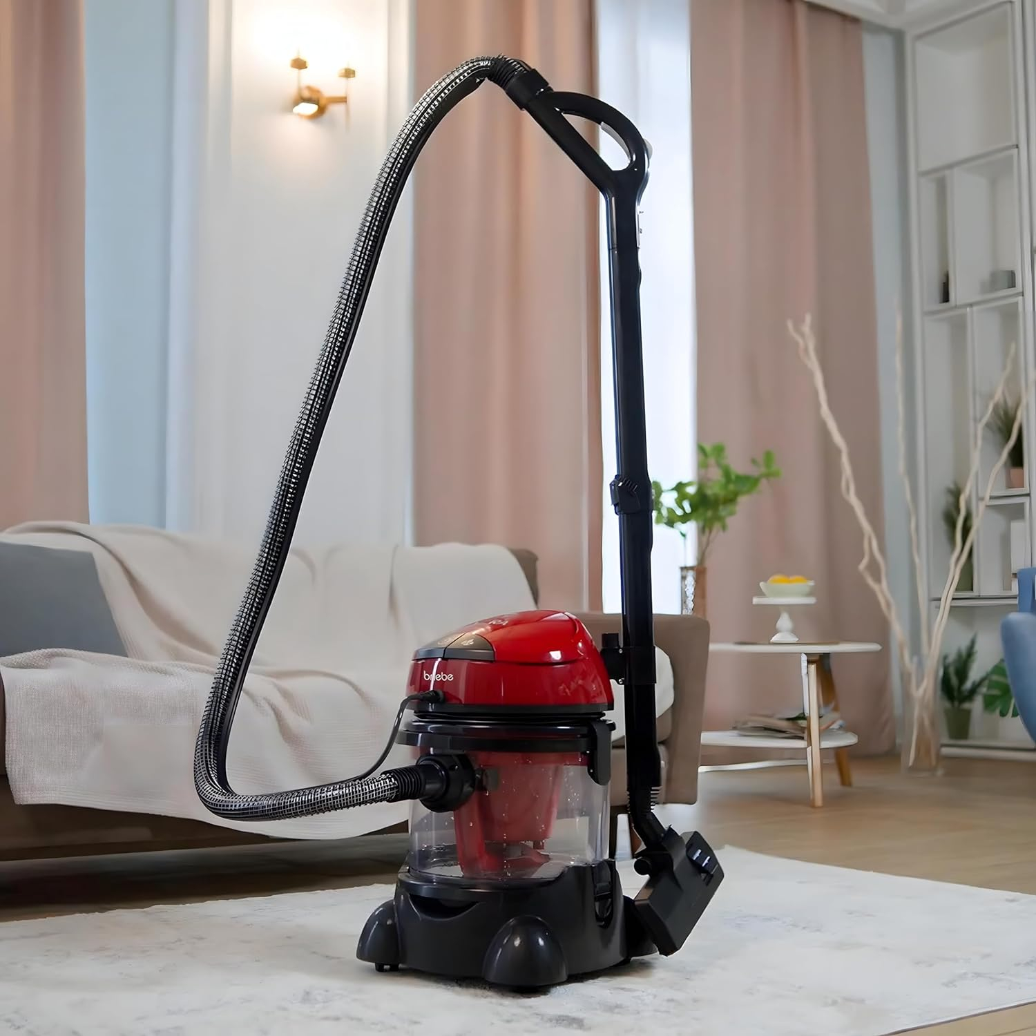 Ein roter Staubsauger mit schwarzer Basis und Schlauch, in einem Wohnzimmer.