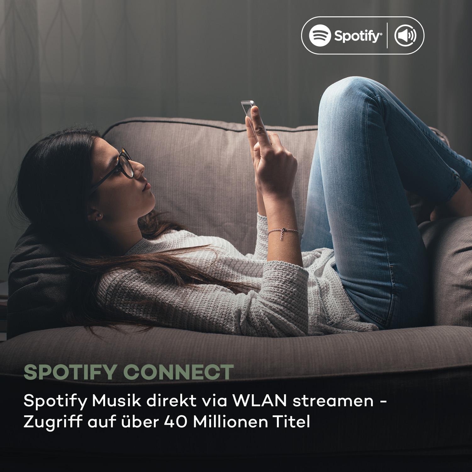 Frau nutzt Smartphone auf Couch, Spotify Connect-Branding in der Ecke.
