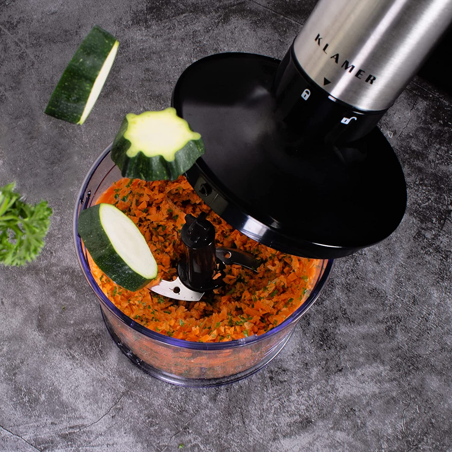 Küchenmaschine mit gehackten Karotten und Zucchini. Geschnittenes Gemüse in der Luft.