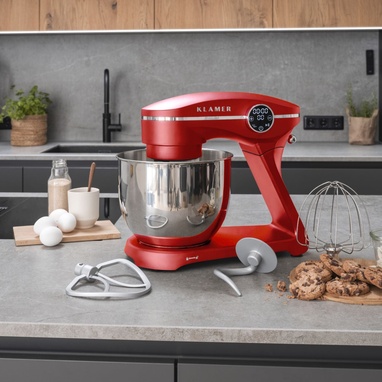 Roter Küchenmixer auf einer Küchenarbeitsplatte. Schüssel und Zubehör sind sichtbar. Küchenumgebung im Hintergrund.