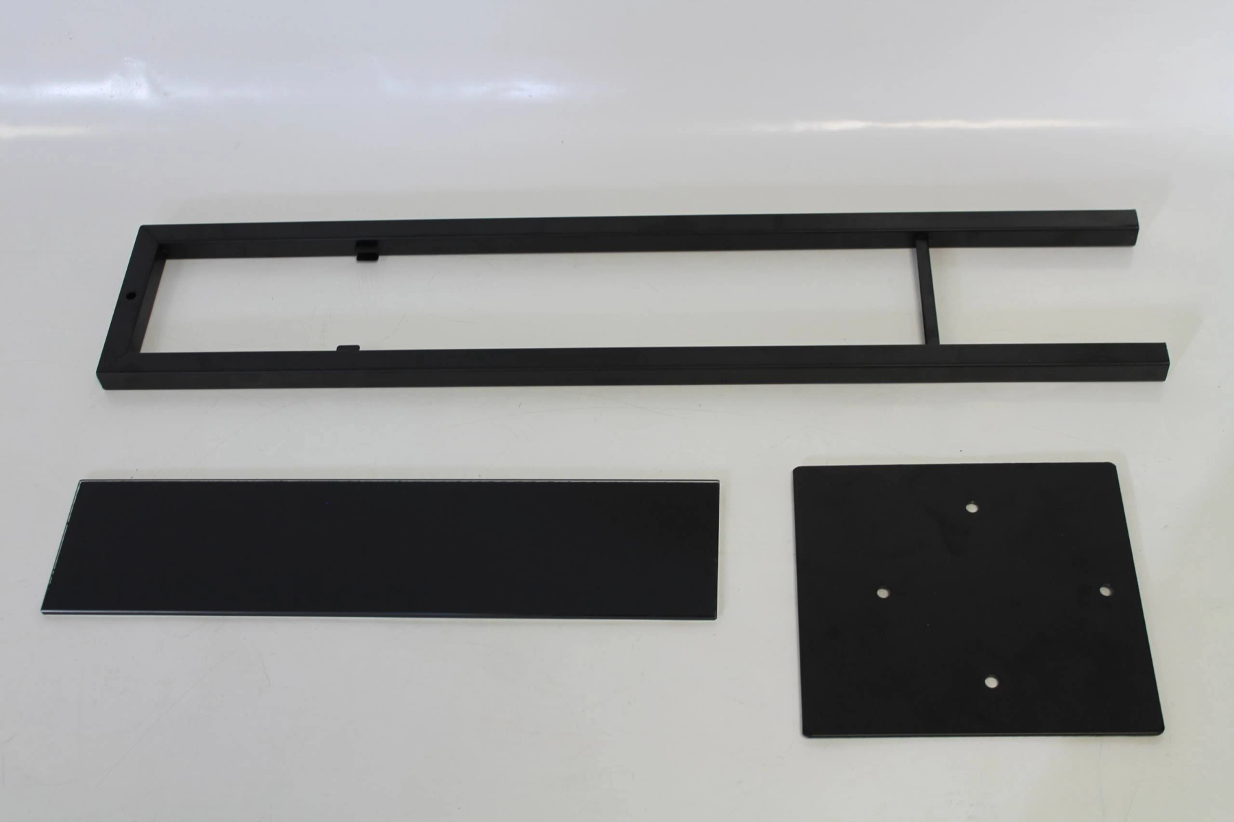 Schwarze Metallrahmenelemente für ein Display, einschließlich Basis und Rahmen.