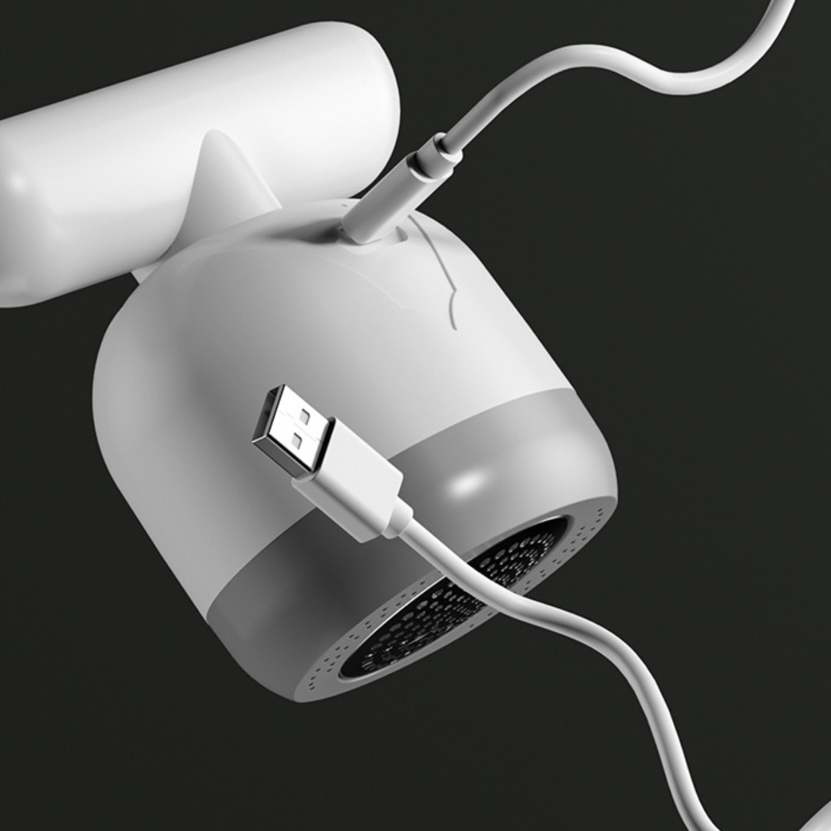 Weißes und graues Haarentfernungsgerät mit eingestecktem USB-Kabel. Dunkler Hintergrund.