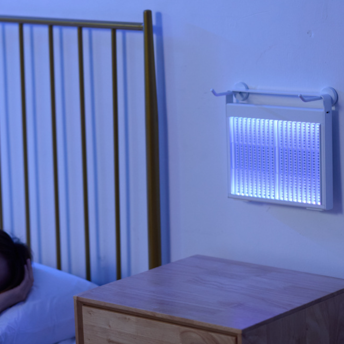 Eine weiße LED-Lichttafel an einer Wand montiert. Eine Person ist auf der linken Seite des Rahmens.