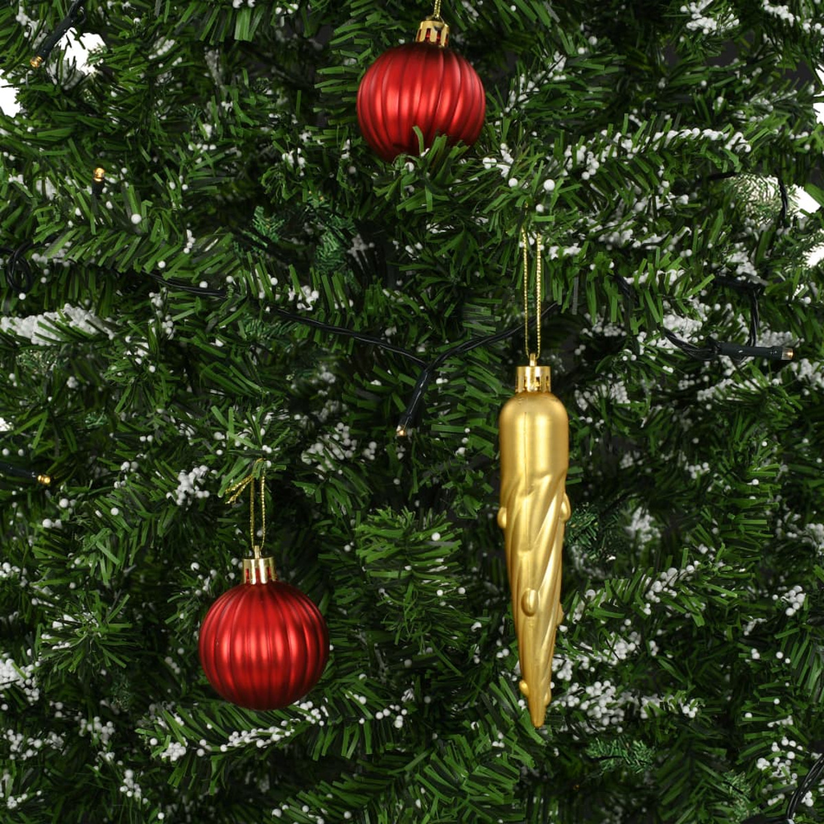 Weihnachtsbaum mit roten und goldenen Ornamenten, weißem Schnee, grünen Nadeln.