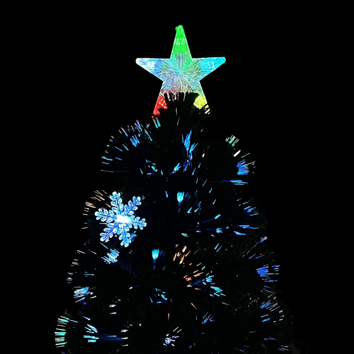 Spitze eines schwarzen Weihnachtsbaums mit Stern und Schneeflocke, beleuchtet mit bunten Lichtern.