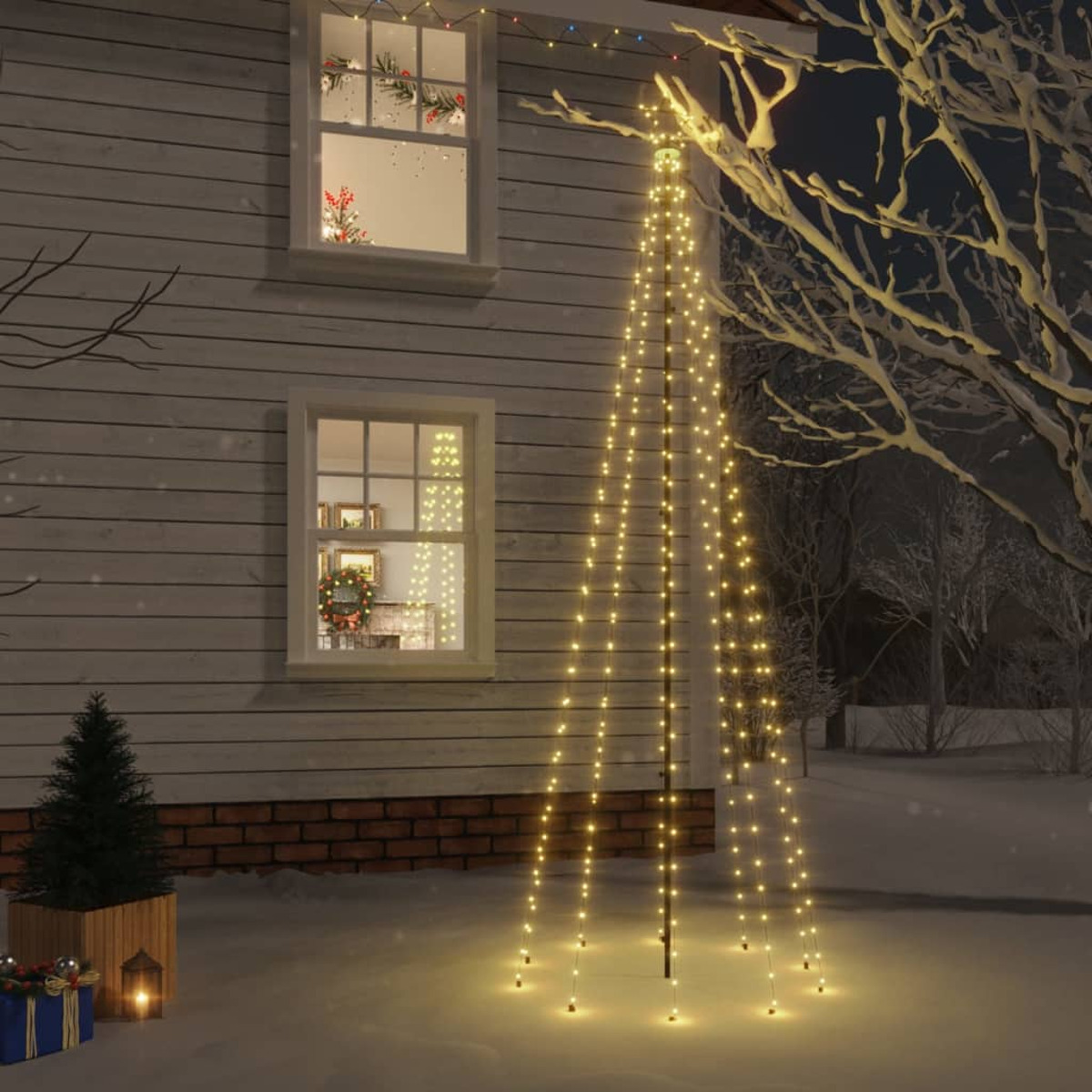 Ein Haus mit Weihnachtsbeleuchtung und Dekorationen. Eine baumförmige Lichtanzeige steht im Schnee. Fenster zeigen Innendekorationen.