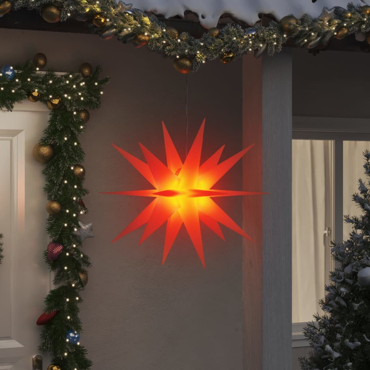 Sternförmige Weihnachtsbeleuchtung. Sie leuchtet orange und hängt über einer Haustür.