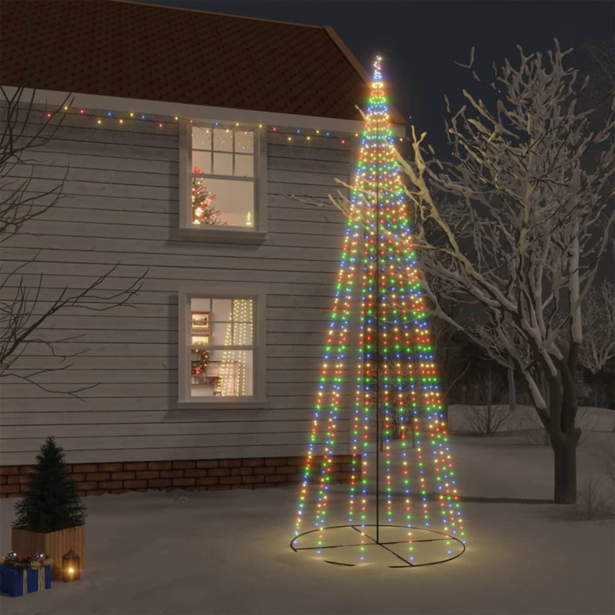 Ein Haus mit einem beleuchteten Weihnachtsbaum davor. Der Baum besteht aus bunten Lichtern.