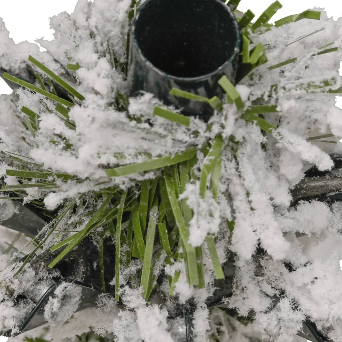 Nahaufnahme eines schneebedeckten künstlichen Weihnachtsbaumfußes und eines schwarzen Ständers.