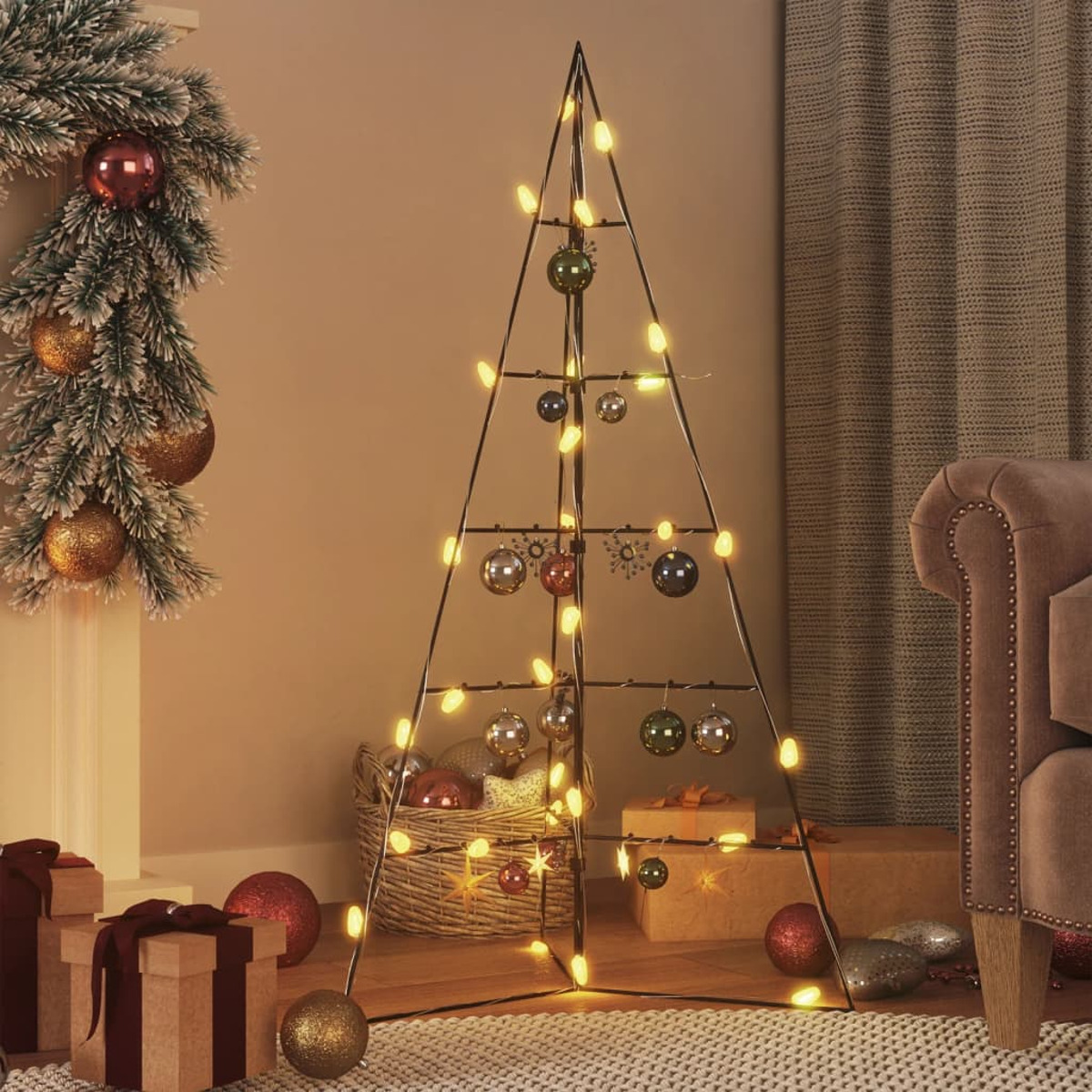 Metall-Weihnachtsbaum mit Lichtern und Ornamenten geschmückt. Geschenke und Deko im Hintergrund.