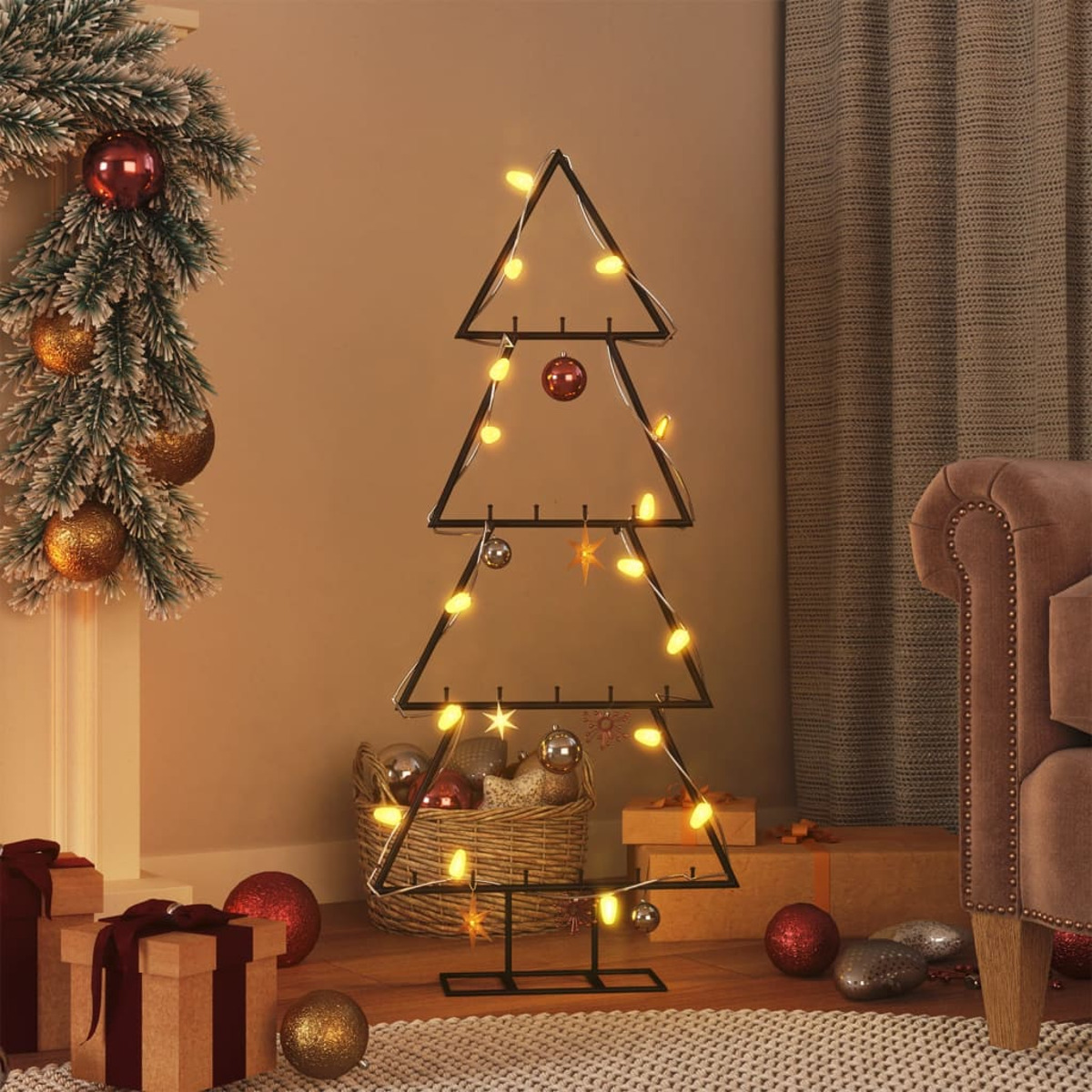 Ein Weihnachtsbaum aus Metall mit Lichtern steht in einem Raum. Ornamente, Geschenke und ein Sofa sind sichtbar. Eine Girlande befindet sich links.