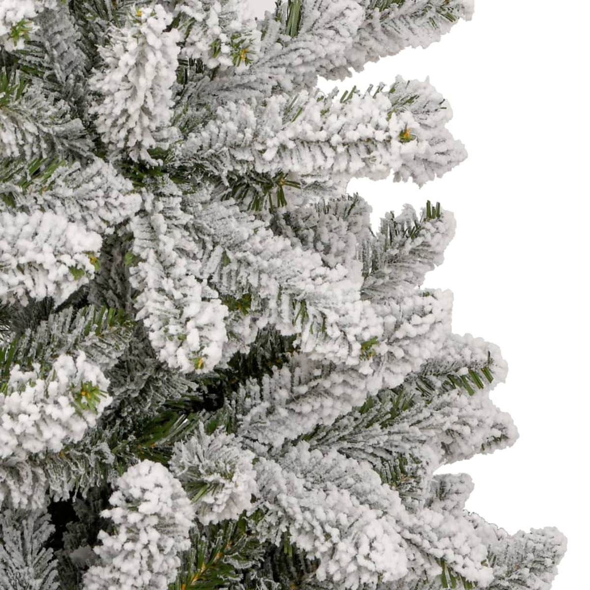 Nahaufnahme von schneebedeckten Tannennadeln auf einem künstlichen Weihnachtsbaum.
