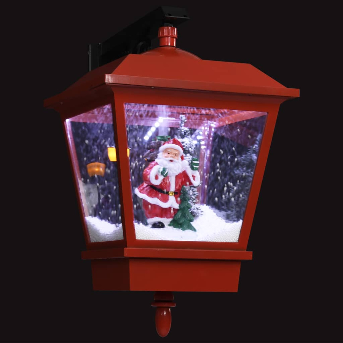Eine rote Weihnachtslaterne mit einer Weihnachtsmannfigur darin, in einer schneebedeckten Szene.