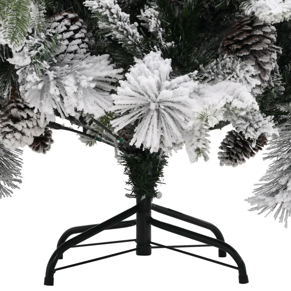 Nahaufnahme des Sockels eines künstlichen Weihnachtsbaums. Äste sind schneebedeckt, mit Tannenzapfen. Ein schwarzer Metallständer trägt den Baum.