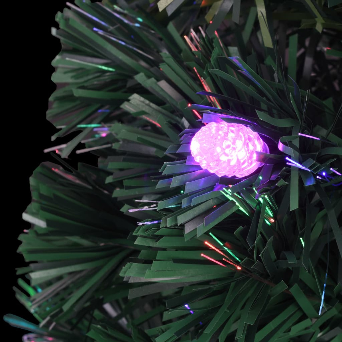 Nahaufnahme eines grünen Weihnachtsbaums mit einem leuchtenden rosa Licht, umgeben von bunten Lichtern vor schwarzem Hintergrund.