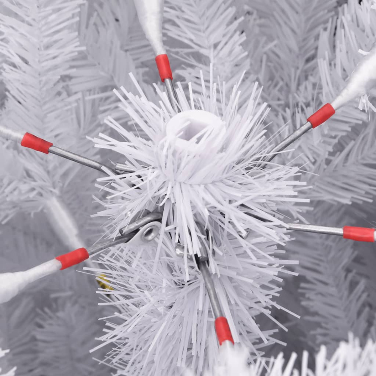 Nahaufnahme einer weißen Weihnachtsbaumverzierung mit roten Spitzen und weißer Basis.