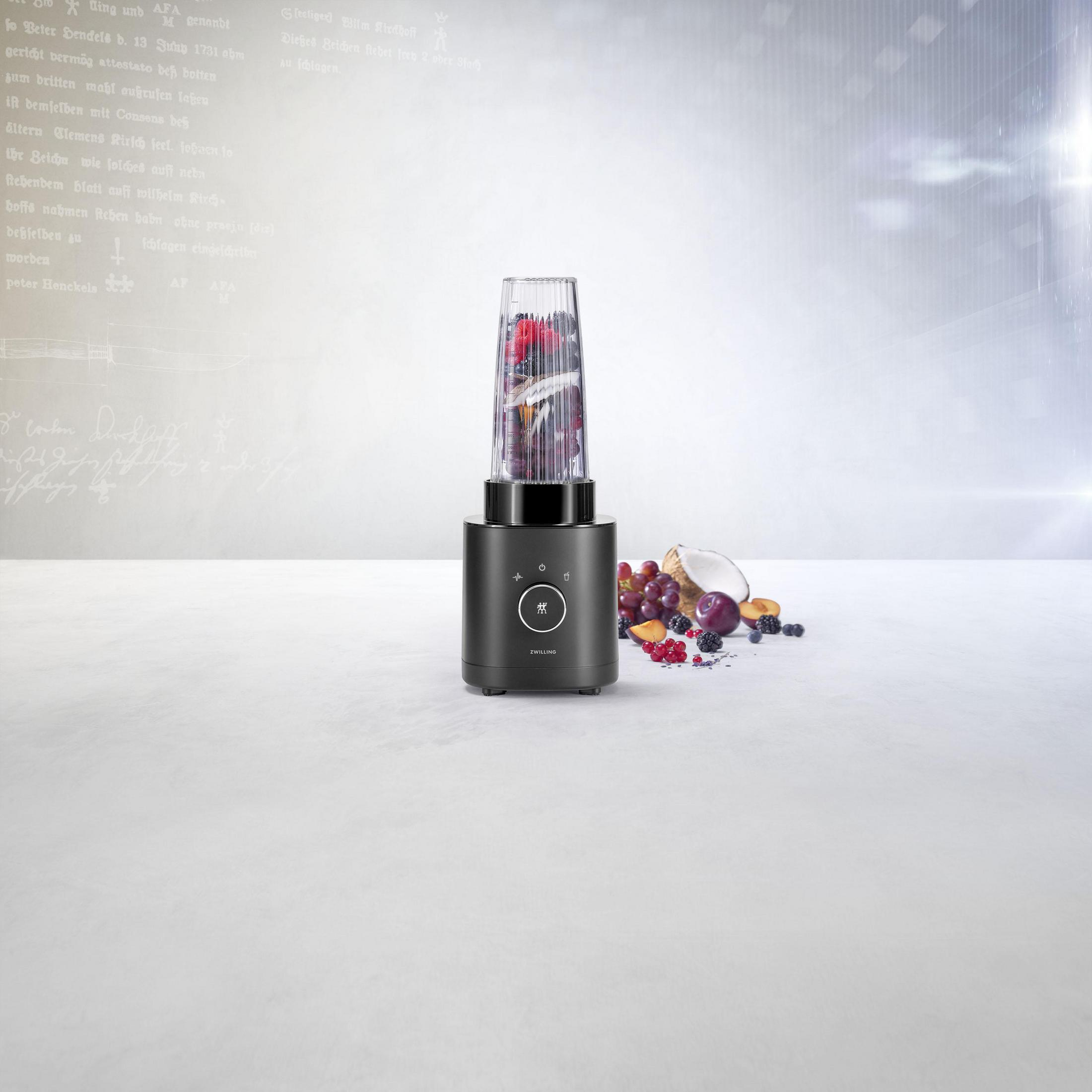 Blender wypełniony owocami na białej powierzchni z tekstem w tle.