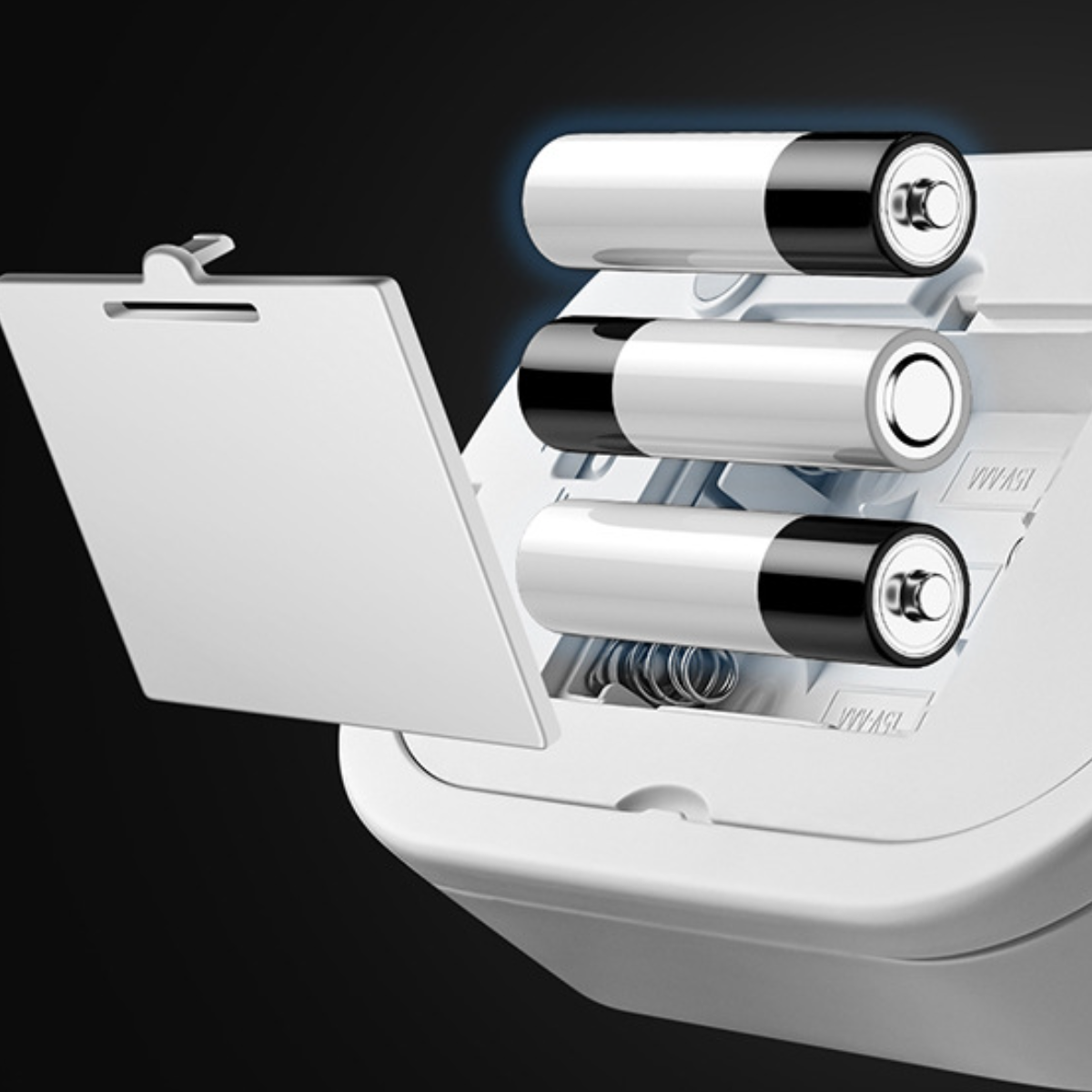 Nahaufnahme eines offenen Batteriefachs mit drei weißen AA-Batterien darin.
