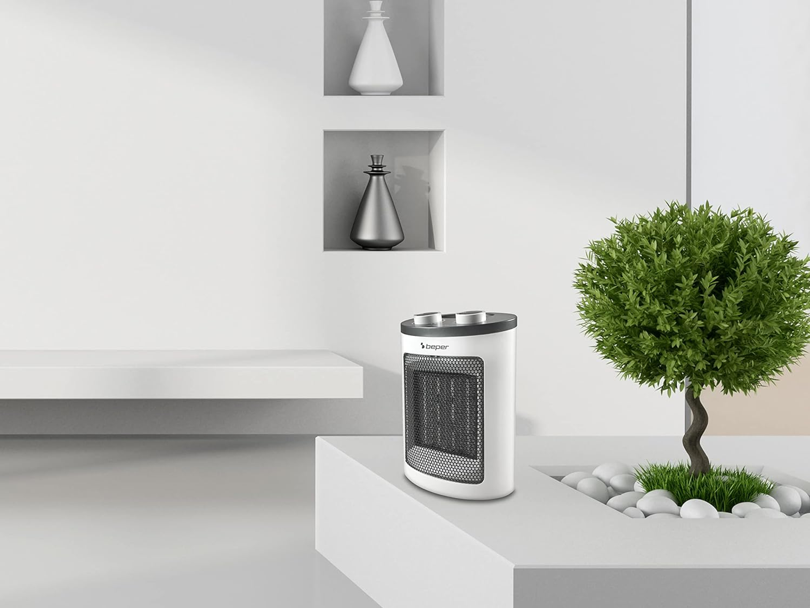 Biały grzejnik elektryczny z czarnym blatem stoi na białej powierzchni obok zielonej rośliny i dekoracji.