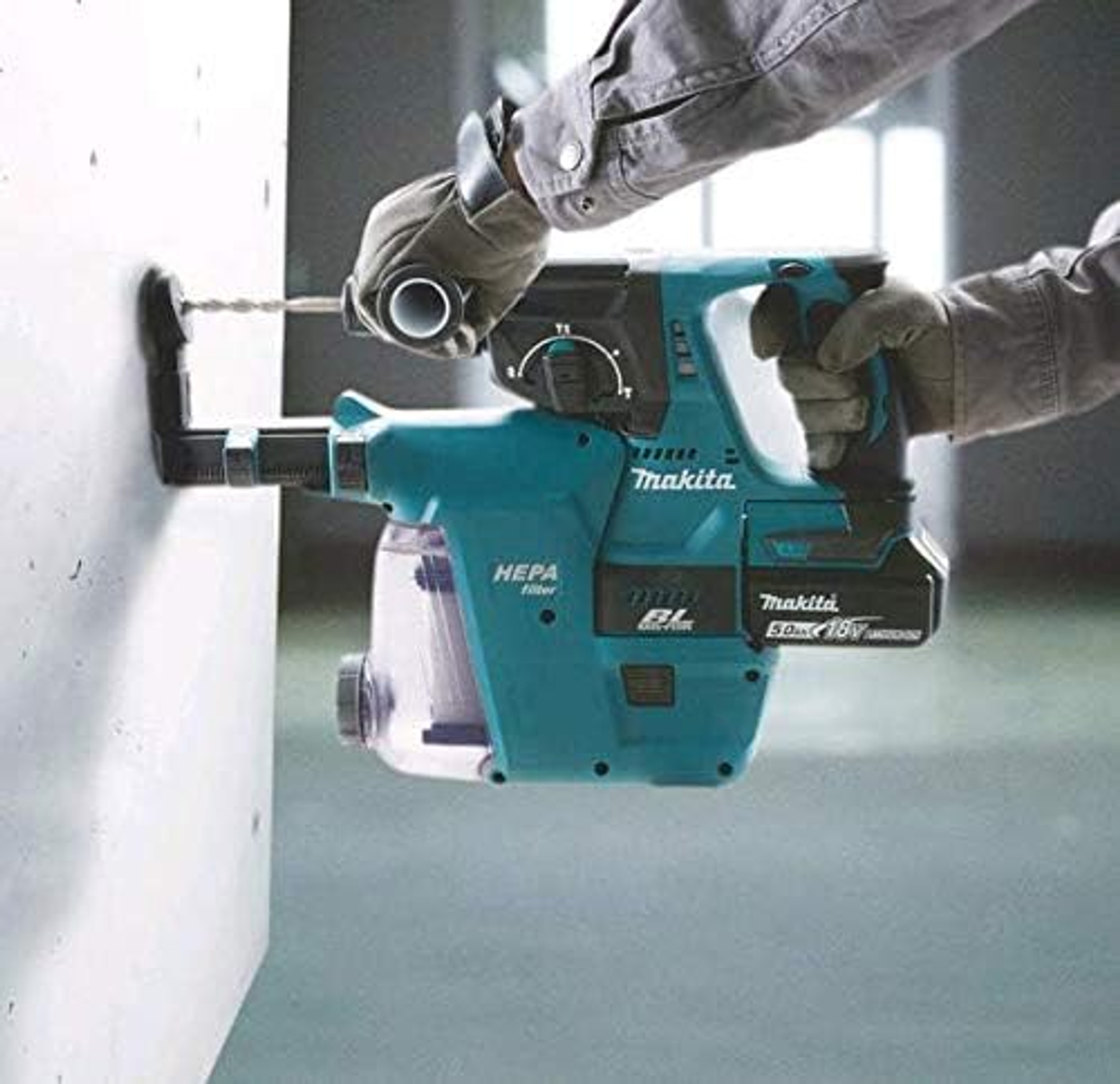 Un uomo sta usando un trapano Makita blu e verde acqua per forare un muro di cemento.