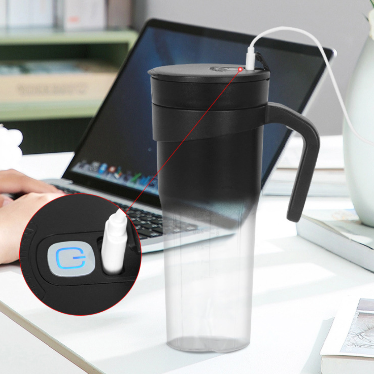 Ein schwarzer und durchsichtiger Becher mit Griff, der an einen Laptop auf einem weißen Schreibtisch angeschlossen ist.