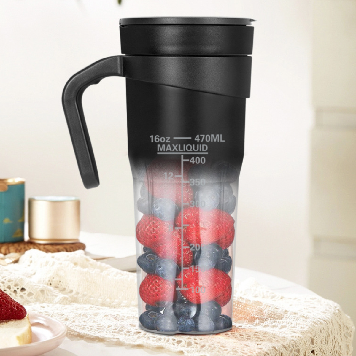 Ein schwarzer Mixer mit Griff, gefüllt mit Erdbeeren und Blaubeeren, mit Messungen.