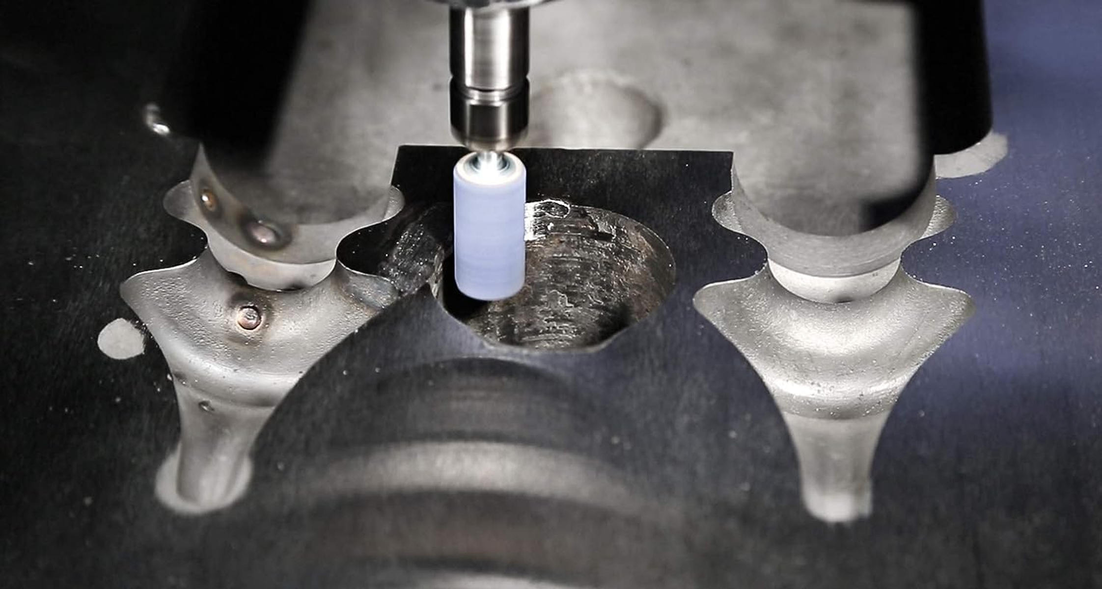 Nahaufnahme einer Maschine, die ein Metallobjekt mit einem Bohrer fräst.